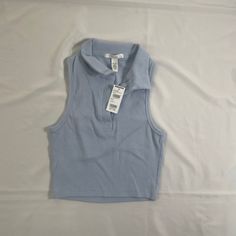 Rsq Women’s Sleeveless Polo Shirt . - Ribbed Construction - Fitted Top - Crop Top - Machine Wash Trendy Blue Tank Vest, Trendy Blue Vest Top, Trendy Light Blue Sleeveless Top, Trendy Sleeveless Blue Vest, Trendy Blue Sleeveless Vest, Trendy Cropped Blue Vest, Blue Cropped Vest For Summer, Stretch Light Blue Sleeveless Top, Light Blue Stretch Sleeveless Top