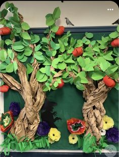 an apple tree made out of paper and other things on the wall in front of it