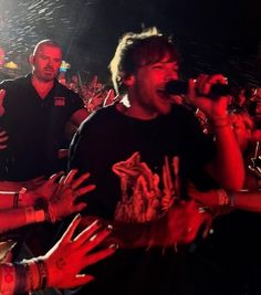 a group of people standing around each other with their hands up in front of them