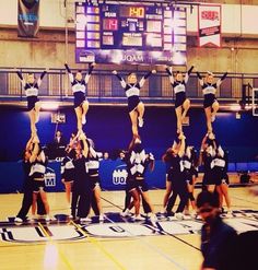 a group of cheerleaders doing stunts on a basketball court