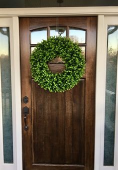 a wooden door with a green wreath on it