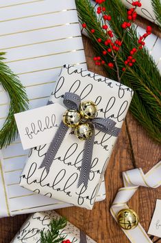 christmas presents wrapped in wrapping paper with bells and holly on the table next to them