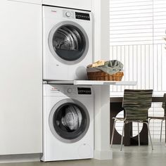 a white washer and dryer sitting next to each other in front of a kitchen table