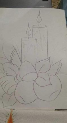 a drawing of a candle and flowers on a piece of paper with scissors next to it