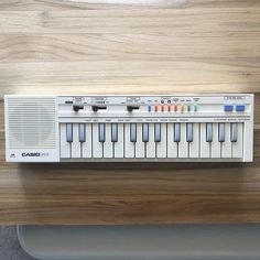 an electronic keyboard sitting on top of a wooden table