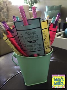 a green bucket filled with lots of pens and writing paper on top of a table