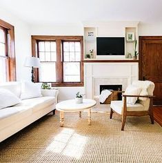 a living room filled with furniture and a flat screen tv mounted on the wall above a fireplace