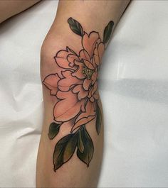 a woman's leg with a flower tattoo on the left side of her arm