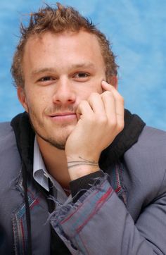 a close up of a person with his hand on his chin and looking at the camera