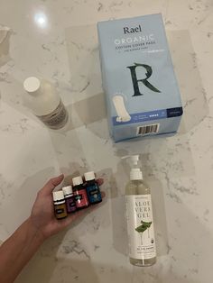 a person holding an item in their hand next to bottles of essential oils and soap