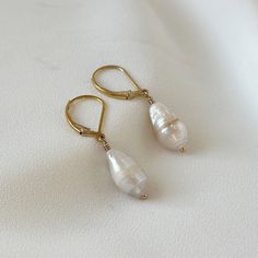 "Introducing Baroque Pearl Earrings in a mesmerizing combination of gold and fresh water pearls. These dangle drop earrings are perfect for the modern woman who loves a touch of elegance in her minimalist style. The beautiful Baroque pearls gracefully dangle from the gold hooks, creating a chic and timeless accessory. Ideal for anniversary celebrations, weddings, or any special occasion, these earrings will make a stunning statement. Give the gift of refined beauty with these Baroque Pearl Minim 14k Gold Filled Pearl Drop Earrings For Anniversary, Teardrop Pearl Charm Earrings In 14k Gold, Teardrop 14k Gold-filled Pearl Earrings For Anniversary, Teardrop 14k Gold Filled Pearl Earrings For Anniversary, 14k Gold Filled Teardrop Pearl Earrings For Anniversary, Formal 14k Gold Filled Earrings With Pearl Charm, Anniversary 14k Gold Filled Pearl Drop Earrings, Elegant Teardrop Pearl Earrings In 14k Gold Filled, 14k Gold-filled Pearl White Earrings With Pearl Charm