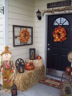 a front porch decorated for fall with hay bales and pumpkins