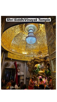 the inside of a temple with people sitting and standing around it, all looking up at the ceiling