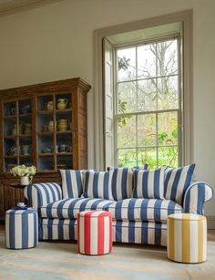 a living room with striped furniture and large windows