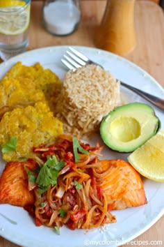 a white plate topped with different types of food next to rice and an avocado