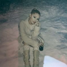 a woman sitting in the snow with her hand on her face