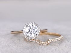 an engagement ring with a twisted band and a round center stone surrounded by small diamonds