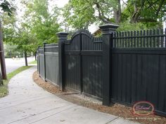 a black fence is next to a sidewalk