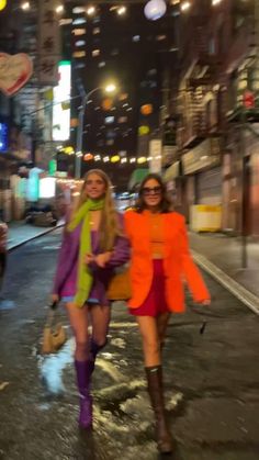 two women walking down the street at night