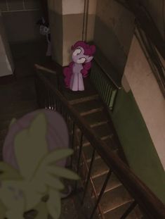 a pink pony sitting on top of a set of stairs