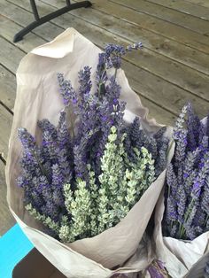 two bouquets of lavender flowers sitting on top of a wooden table