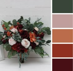 a bouquet of flowers sitting on top of a table next to a white frame and color swatches