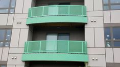 an apartment building with green balconies on the balcony