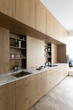 a kitchen with wooden cabinets and marble counter tops