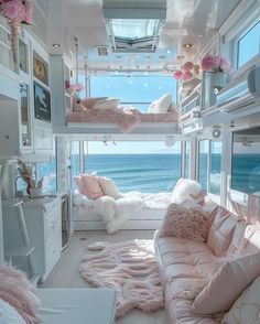 a room with bunk beds and pink fur rugs on the floor next to the ocean