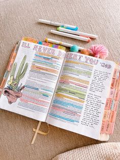 an open bible next to crayons and markers