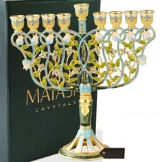 a blue and gold menorah sitting on top of a green box next to it's contents