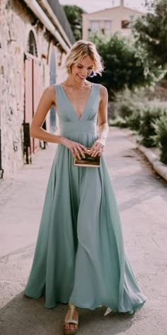 a woman in a blue dress is walking down the street with her hand on her purse