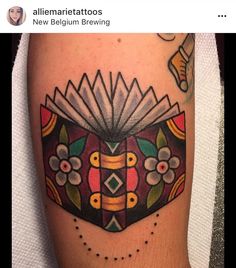 an open book tattoo on the leg