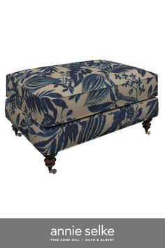 an upholstered blue and white floral print footstool