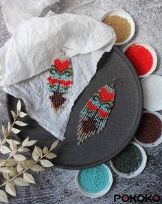 two pairs of beaded earrings sitting on top of a tray next to some bowls