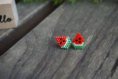 two pieces of beaded fruit sitting on top of a wooden table next to a box