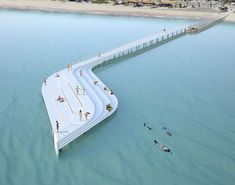 an artist's rendering of a floating walkway in the water with people swimming on it