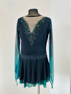 a woman's figure skating dress with sequins and beads on the shoulders