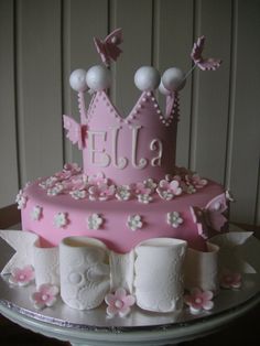 a pink cake decorated with flowers and butterflies