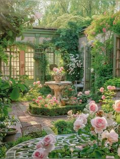 a garden filled with lots of flowers next to a small table and chairs in front of a fountain