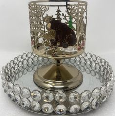 a glass candle holder with a bear on it and some crystal beads around the base