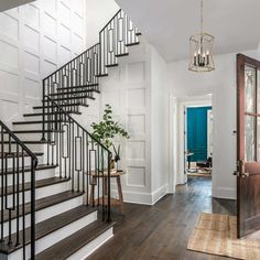 a foyer with white walls and wood floors