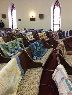 rows of chairs with quilts on them in a church