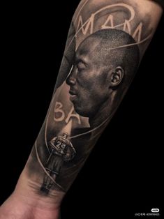 a man's arm with a black and white tattoo on it that reads, mamba