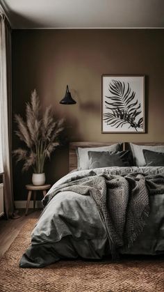 a bedroom with a large bed covered in grey linens and pillows next to a window