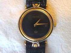 Sharp and modern vintage Gucci 4500M women's quartz watch, features thin two-toned gold and silver filled 32mm stainless steel case with a black face and black polished original lizard band (some wear, but in good condition) 1990s ladies wrist watch. Analog display, Swiss quartz movement, runs like a champ! Comparable models new go for easily over 1k. The band measures tip to buckle 8 inches and 1/2 inch band width at lug and tapers. A stylish go-to versatile time piece for office to evening in Ladies Wrist Watch, Tone Face, Gucci Watch, Watch Gifts, Women Wrist Watch, Gucci Black, Vintage Modern, Ladies Watch, Black Watch