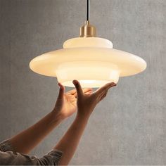 a person reaching up to a light fixture