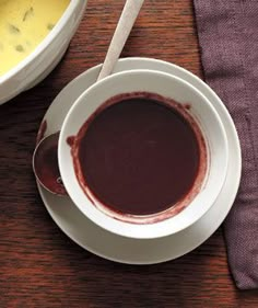 there is a bowl of soup on the table with a spoon in front of it