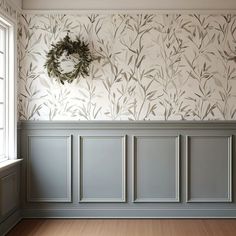 an empty room with wallpaper and a wreath hanging on the wall next to it