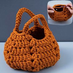 an orange crocheted purse is being held up by someone's hand with their right hand